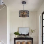 Industrial pendant light with wood accents, viewed from below, highlighting the three bulb sockets and cage structure.