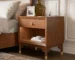 Modern nightstand with USB port and gold capped legs in walnut finish