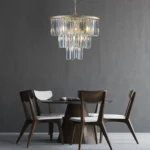 Goldoma 20-inch 3-tier crystal chandelier with gold frame and 7 candle-style lights, hanging in a modern living room.