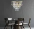 Goldoma 20-inch 3-tier crystal chandelier with gold frame and 7 candle-style lights, hanging in a modern living room.