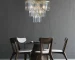 Goldoma 20-inch 3-tier crystal chandelier with gold frame and 7 candle-style lights, hanging in a modern living room.