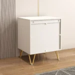 Modern nightstand with drawers, gold legs, and 3D embossed design in a bedroom setting