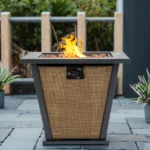 Outdoor gas fire pit column with dancing flames on a patio