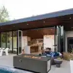 Rectangular propane fire pit table with flames on a patio
