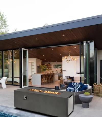 Rectangular propane fire pit table with flames on a patio