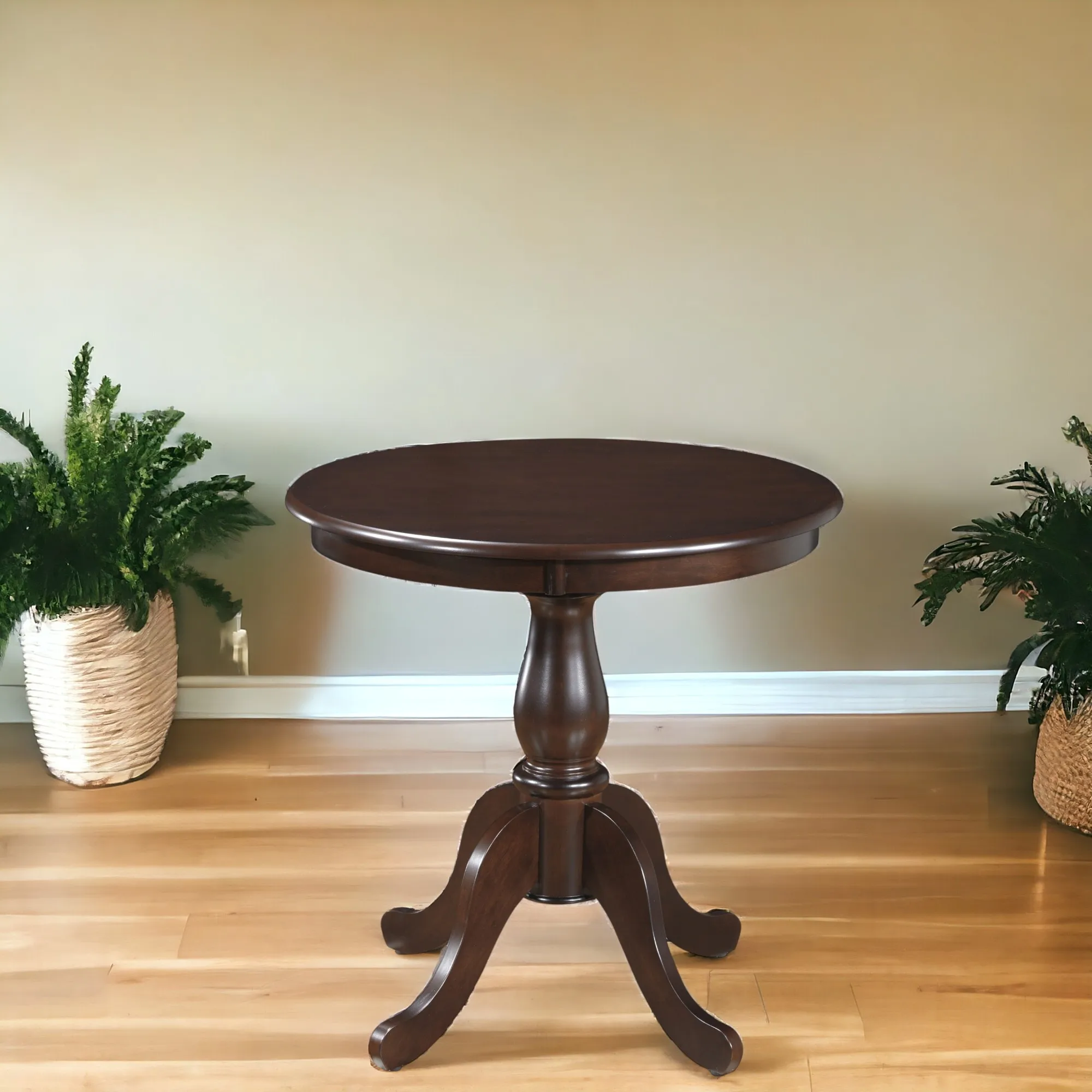 Small round dining table in espresso finish with pedestal base in a cozy dining room