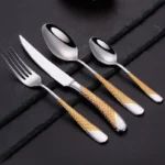 Goldoma stainless steel cutlery set with gold accents on a dining table