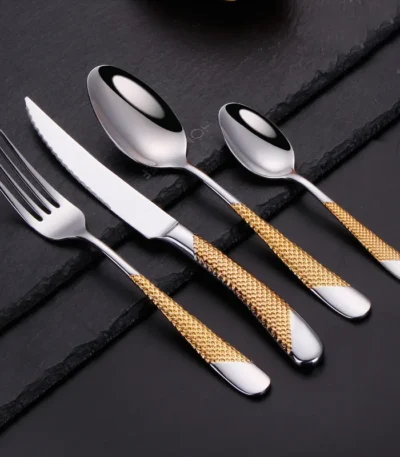 Goldoma stainless steel cutlery set with gold accents on a dining table