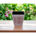 Brown and off-white recycled plastic square planter with tone-on-tone textural design, set on a wooden deck with