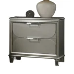 Silver traditional nightstand with acrylic handles and embossed panels in a bedroom