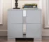 Modern gray nightstand with drawers, mirrored panel, and metal feet in a bedroom setting