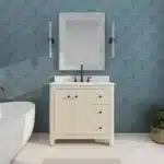 Modern freestanding bathroom vanity with sink, soft close drawers, and a sleek white countertop in a bright bathroom.