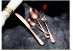 Elegant gold flatware set with fork, knife, and spoon on a white tablecloth