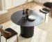 Mid century dining table round black MDF with four chairs in a modern dining room