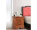 Oak wood nightstand with two drawers in a cozy bedroom setting