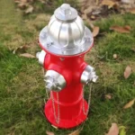 Fire hydrant decoration under a tree, dappled sunlight on the ground.
