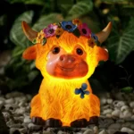 White resin Highland cow solar garden statue with flower crown on grass, sunny day
