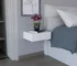 Milano floating nightstand with drawer mounted on white wall, holding a lamp and book
