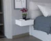 Milano floating nightstand with drawer mounted on white wall, holding a lamp and book