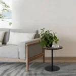 Set of two small round side tables with concentric circle walnut wood tops and black metal pedestal bases, modern design for living room or bedroom
