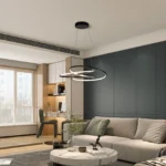 Modern LED pendant light with black metal frame, hanging over a wooden dining table in a bright living room with soft