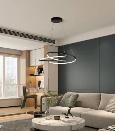 Modern LED pendant light with black metal frame, hanging over a wooden dining table in a bright living room with soft