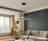 Modern LED pendant light with black metal frame, hanging over a wooden dining table in a bright living room with soft