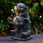 Goldoma elephant solar garden statue light on a sunny patio, resin material with weathered stone finish, side view