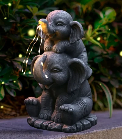 Solar elephant statue glowing at night in garden with warm LED light