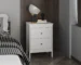 White nightstand with drawers in a modern bedroom setting
