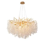 Gold crystal chandelier hanging in modern dining room with golden light reflections