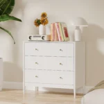 Modern white 3 drawer dresser with gold-tone knobs and lacquer finish in a bedroom setting
