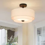 Pendant light installed in a dining room setting above a wooden table, with the two tiers clearly visible.