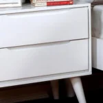 Modern white nightstand with 2 drawers and tapered legs in a bedroom setting