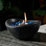 Black concrete mini tabletop fire pit with smokeless ethanol flame on a wooden table