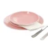 Elegant pink dinnerware set with plates and bowls on a wooden table