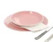 Elegant pink dinnerware set with plates and bowls on a wooden table