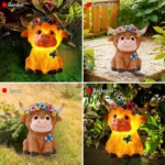 Pair of Highland cow statues, one with flowers, in a garden setting with sunlight