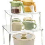 Clear acrylic countertop storage shelves with stacked spice jars on a kitchen counter