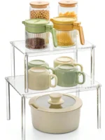 Clear acrylic countertop storage shelves with stacked spice jars on a kitchen counter