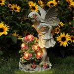 Solar resin angel statue glowing softly in a flower garden at dusk.