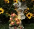 Solar angel statue glowing in a garden at night