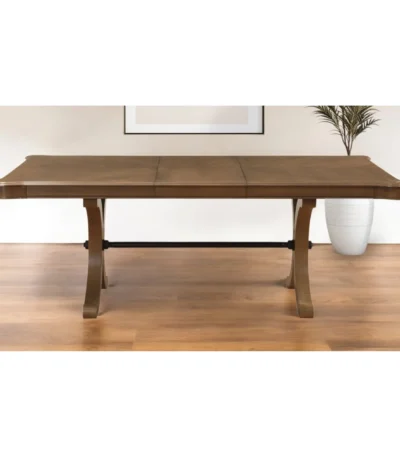Goldoma 64-inch brown solid wood dining table with removable leaf and trestle base, set in a dining room