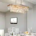 The farmhouse iron ceiling light hangs above a dining table, with crystals catching light in a cozy interior setting.