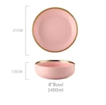 Elegant dinnerware set with gilt rim pink porcelain plates, bowls, mugs, and cutlery on a table