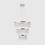 Chandelier hanging over a modern staircase, with crystals sparkling and casting prismatic shadows.