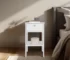 White nightstand with drawer and open shelf in a modern bedroom setting