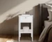 White nightstand with drawer and open shelf in a modern bedroom setting