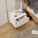 Modern nightstand with drawers, gold legs, and 3D embossed design in a bedroom setting