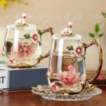Elegant crystal glass tea mug with enamel floral design and handgrip on a wooden table